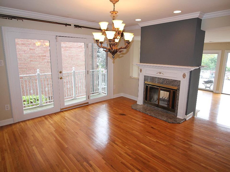Dining room with balcony, fireplace, chandelier, hard wood floors and hi hat lighting
