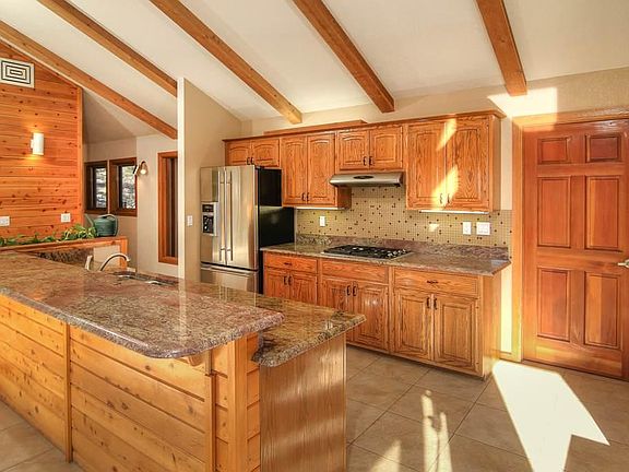 Kitchen with high top bar. Wolf gas cooktop. Custom granite.