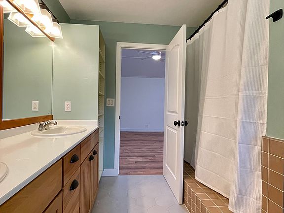 Newly tiled and refinished bathroom, with bathtub.