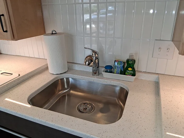 The kitchen is stocked with dish soap and scrubbers