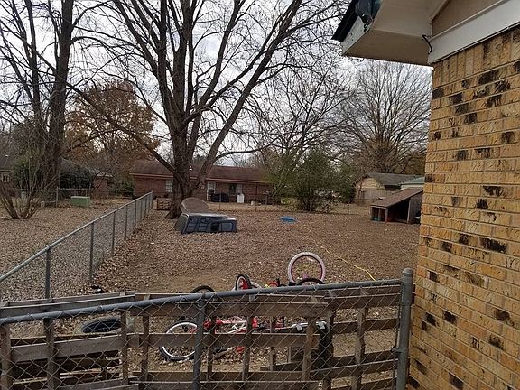 Large fenced-in backyard with dog house