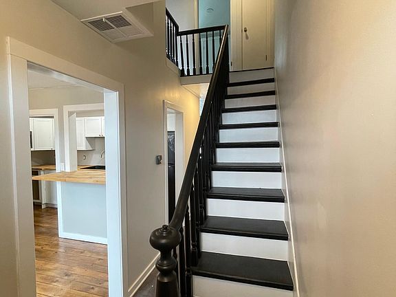 Entryway with kitchen and dining room to the left and family room down the hall.