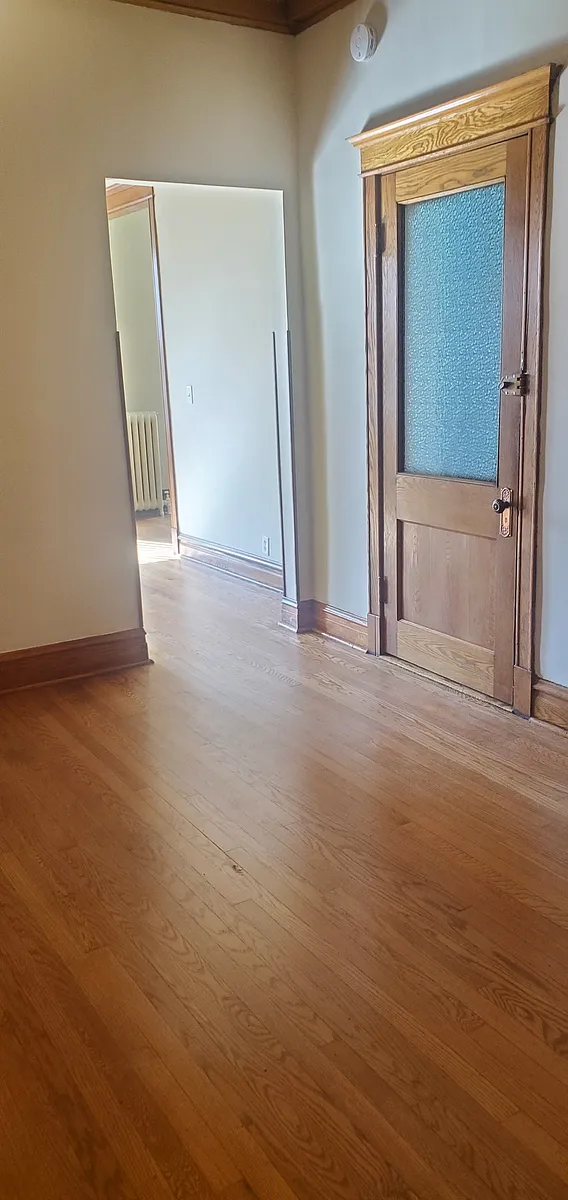Dining-room: Entrance into unit Dining-room from front hallway. Doorway at left to Living-room. Vintage Snowflake Glass oak door. - 1851 S Troy St #2