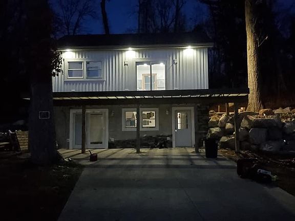 Front view of house at night from driveway - cement driveway.