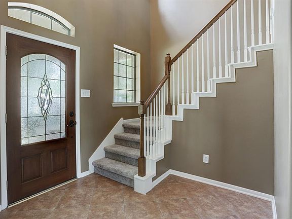 Enter the home through the beautiful lead glass door into the diagonal tiled 2 story entry. Stairwell to the upstairs features a window for extra light.