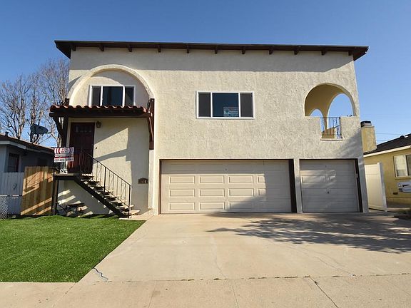 Street view. On right is one car garage and additional parking spot, and entrance path to back unit.
