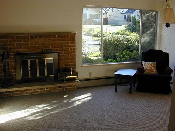 Good sized living room with wood burning fire place and lots of light.