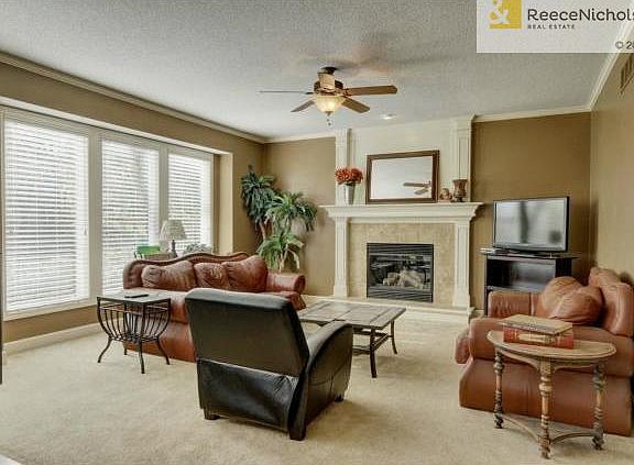 Family room boasts fireplace, ceiling fan & plenty of natural li