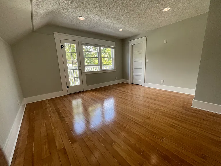 North Bedroom with Closet Door, North Balcony is on other side of panel door and windows.