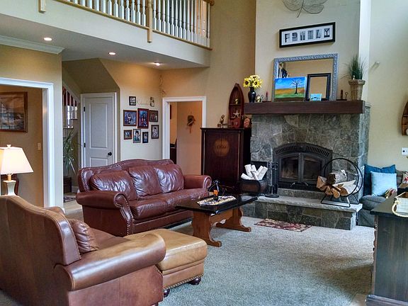 Spacious, open living room with a wood buring stone fireplac