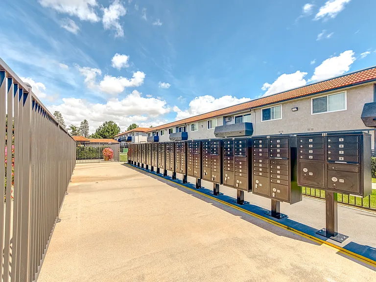 a row of metal mailboxes enclosed in a gated area