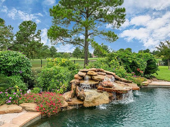 The backyard oasis features a saltwater pool with Pebble Tec siding, waterfall, spa, beach entry and nearby gas firepit.