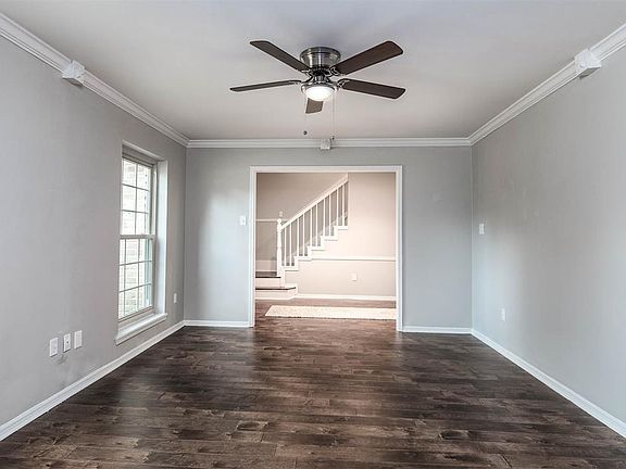 Located near the entrance is the lovely den! Featuring beautiful floors, ceiling fan with lighting, crown molding, and large windows.