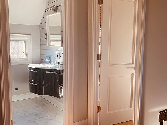 Floating sink bathroom with aluminum slatwall and marble floor