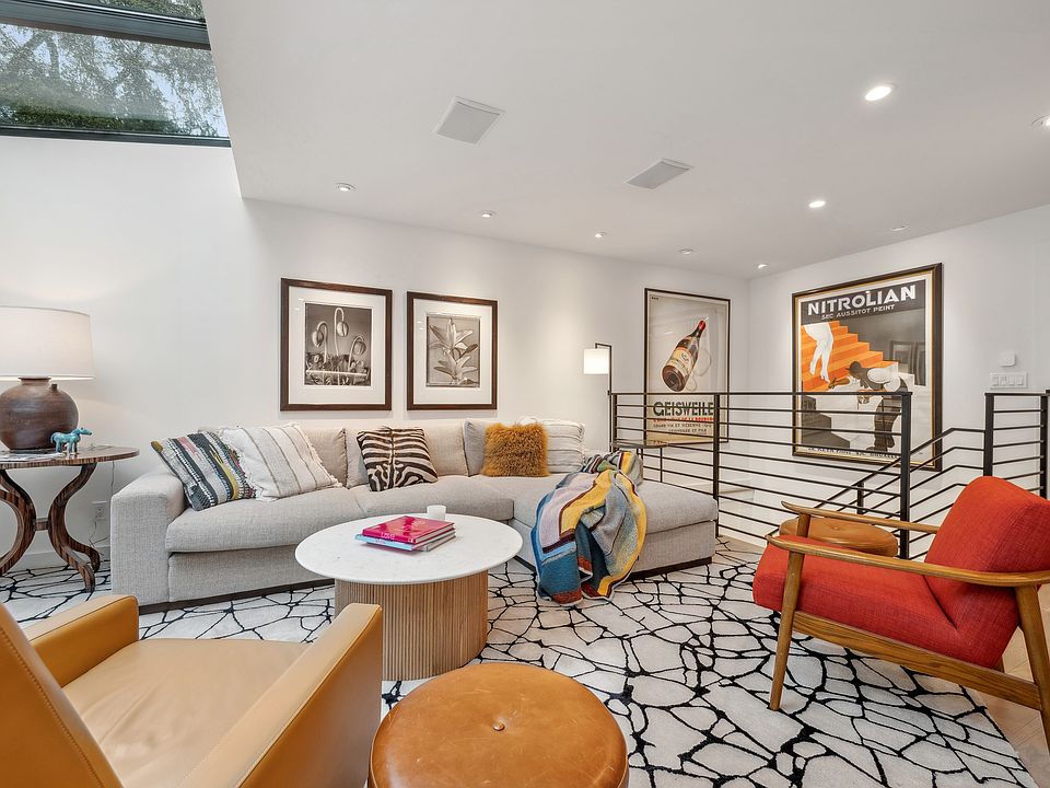 Living room view showing speakers and recessed lights, and skylights across rear of flat