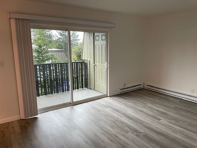 Living room with balcony access and wood plank floors