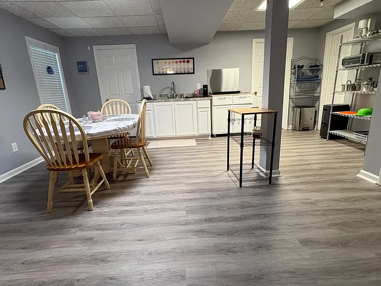Open-concept kitchen and dining area with ample cabinet storage, prep counter with sink, and convenient shelving for pantry i