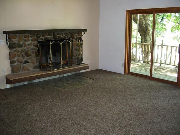 Living Room with new carpeting and full wall of patio doors looking over the lake.