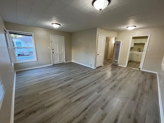 Bright, airy living room features multiple windows and newer luxury vinyl flooring throughout.