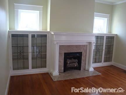 Fireplace in living room : Fully restored and flanked by lead-glass book cases.