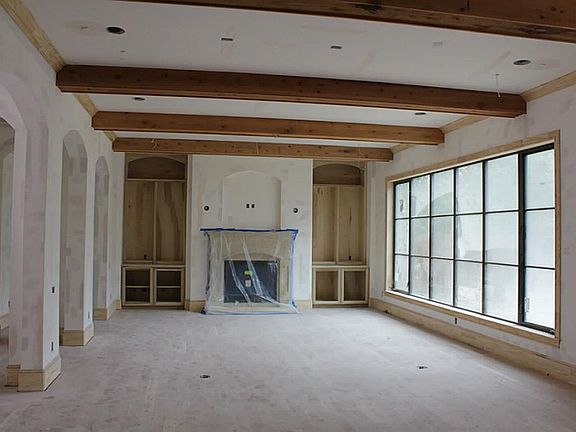 Den with wall of windows and door accessing summer kitchen features hardwood floors, fireplace and b