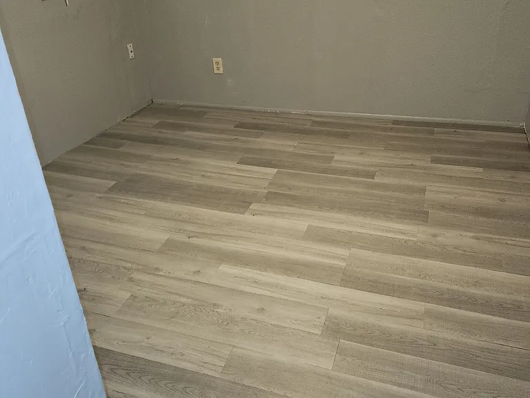 This is a photo of the third bedroom. The floors are newly installed.