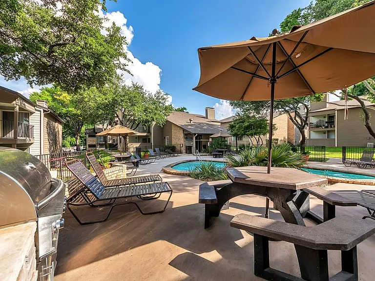 Outdoor resident picnic and grilling area with shaded seating