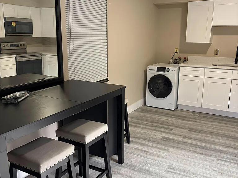 Convenient kitchen and utility area with shaker cabinets, ample counter space, and in-home laundry for everyday ease.