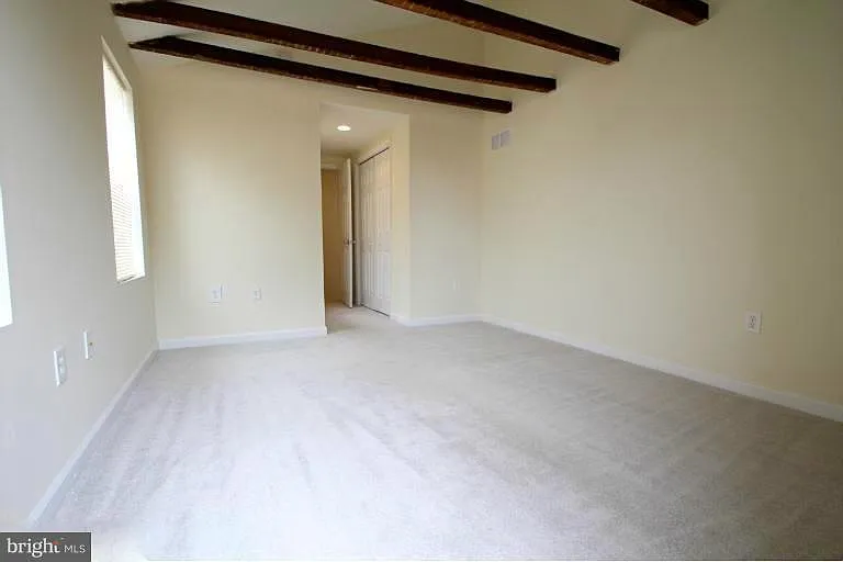 2nd Floor: Medium Sized bedroom viewing toward front of house with windows overlooking private alley on left.