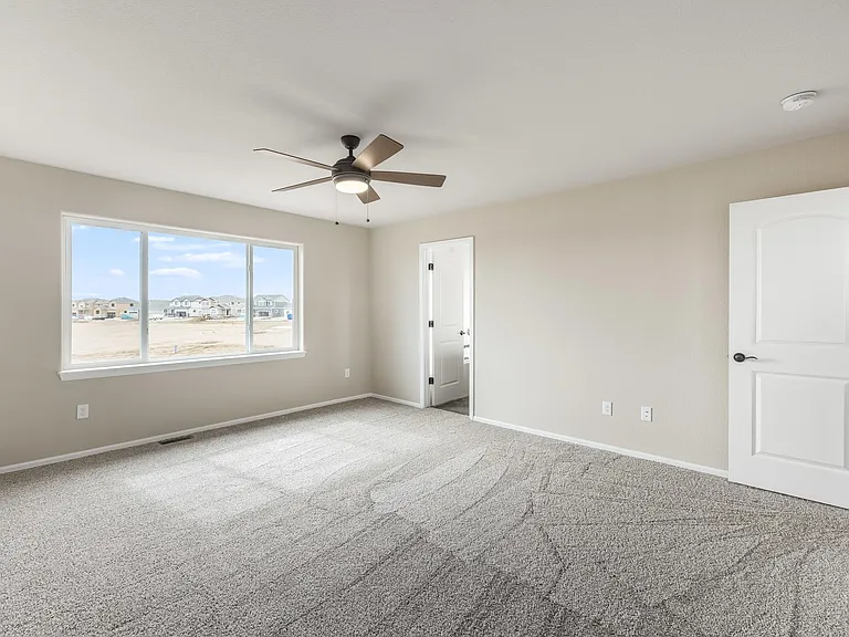 Large primary bedroom with fan, new carpet and attached 5 piece bathroom/walk-in closet