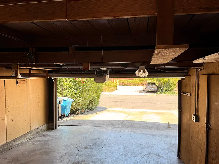 open garage, attic space, and cabinetry