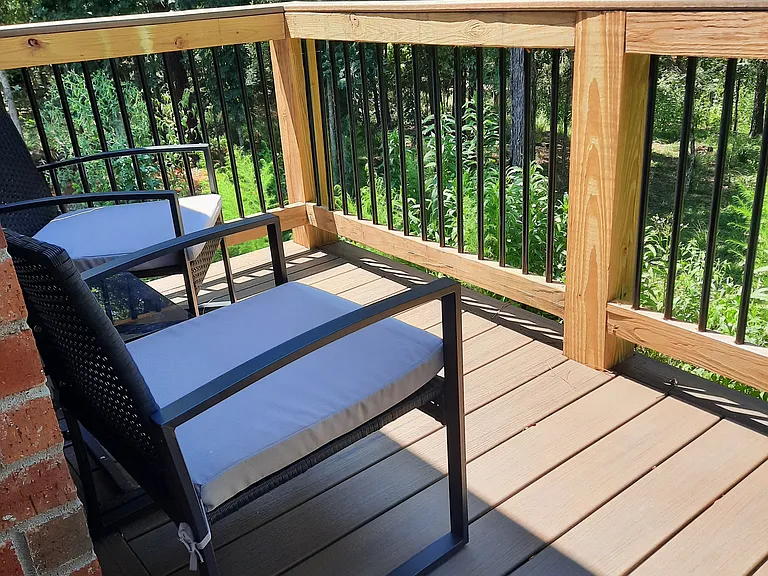 Forest deck, stairs lead down to the concrete BBQ patio.