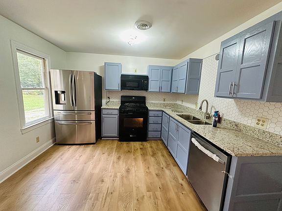Kitchen with new floors, freshly painted cabinets, new dishwashers and new fridge