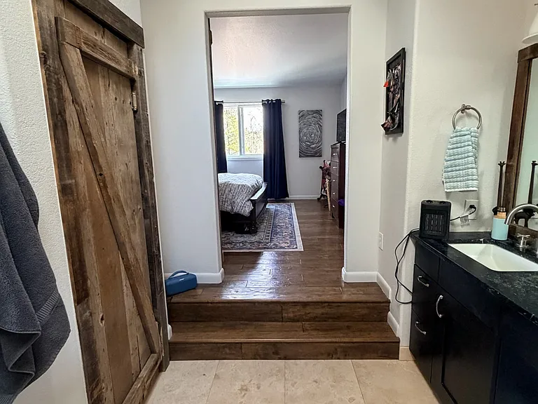 Master bathoom view into master bedroom. Walk in closet, heated tile floors and beautiful hardwood floors in bedroom