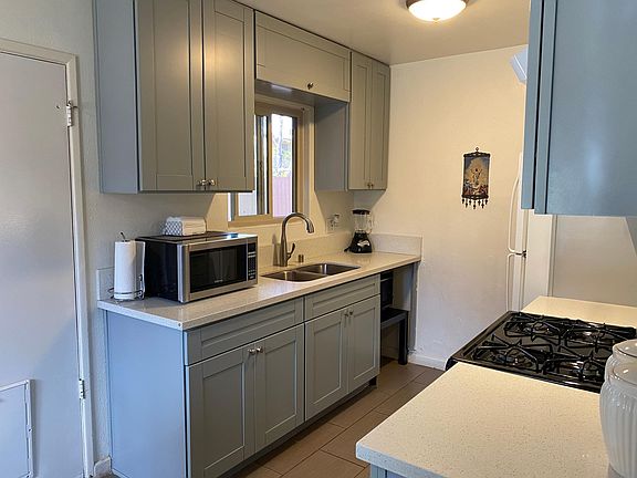 Beautiful modern kitchen with grey shaker cabinets and quartz countertops!