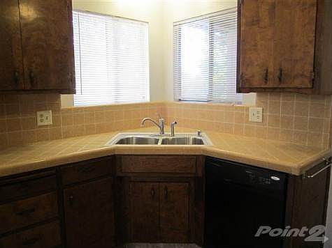 Corner sink in kitchen with newer dish washer and newer sink.