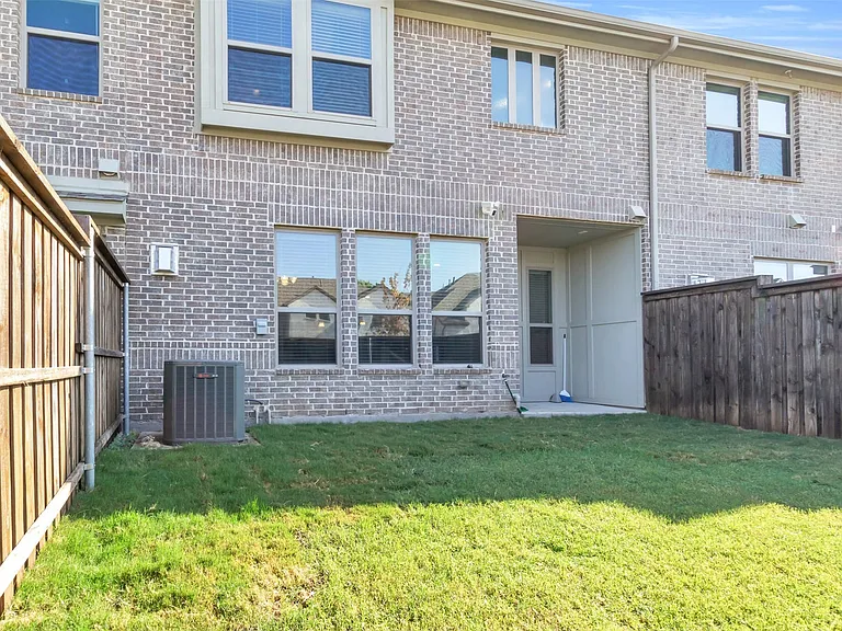 Private backyard space featuring a brick exterior and a privacy fence