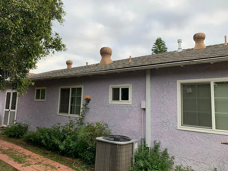 Back of the single family house. The Master Suite has its own separate entrance from the side yard's brown wooden gate.