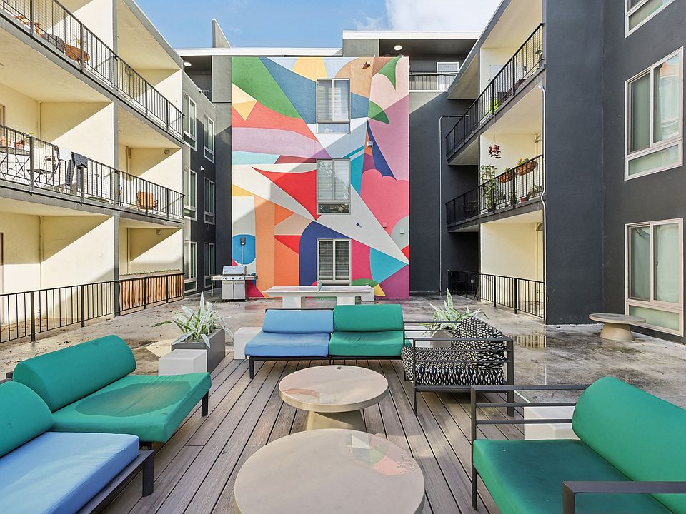 Vibrant courtyard with a large mural, furnished with variety of seating options