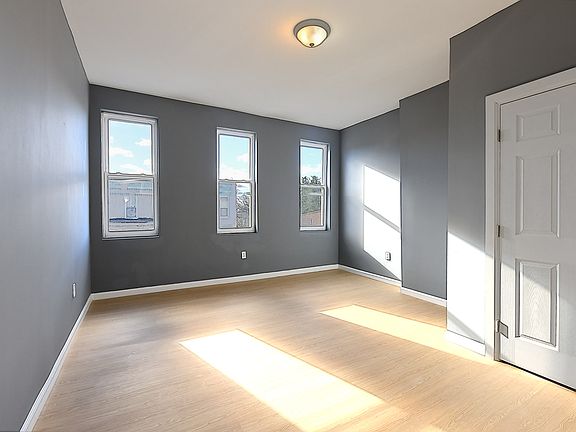 Bedroom 1 is located at the front of the unit, offering a spacious layout with ample natural light from large windows, creating a bright and inviting atmosphere.