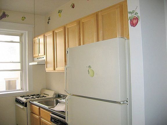 SunnyWalnut Cab Kitch& fruit decor in kitchen w large self-defrosting fridge.