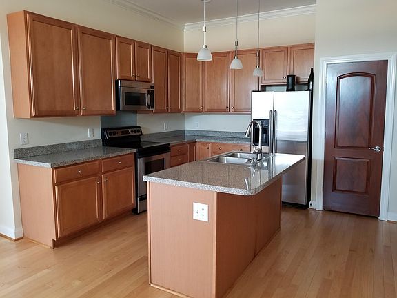 Kitchen with island, pendant lighting, and all appliances