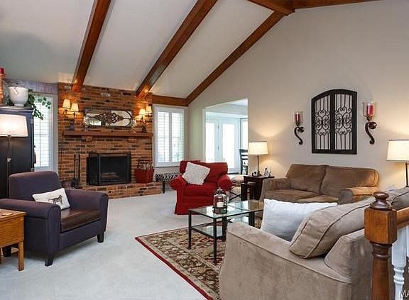 Great room with newer carpet, vaulted ceiling and open to step u