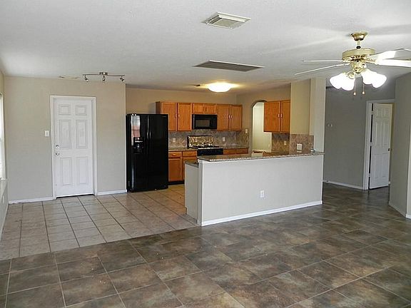 A view of the kitchen with Breakfast bar and good sized breakfast area and fully tiled