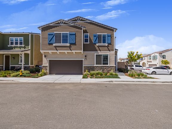 Front view of a modern two-story home with a spacious driveway, landscaped yard, and large windows offering great natural light _ perfectly located in a quiet, family-friendly Menifee neighborhood.