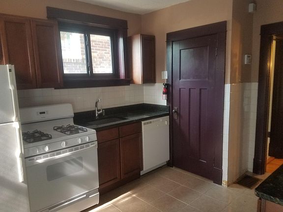Kitchen with granite counter tops and white appliances (refr