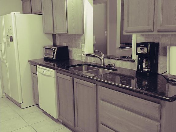 Kitchen has granite countertops and travertine backsplash. R