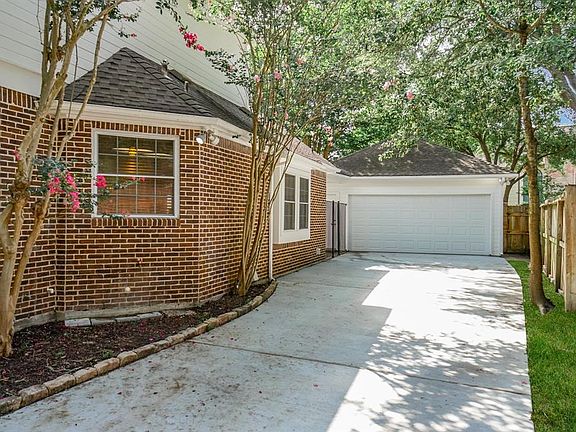 Beautiful crepe myrtles outline the side of the home and resurfaced driveway! The double wide garage has a large storage area above with attic stairs. You enter the breezeway through an updated tall black steel gate.