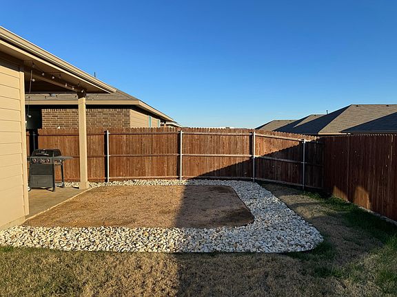 Dedicated crushed granite patio extension with decorative rock border perfect for extra seating area.