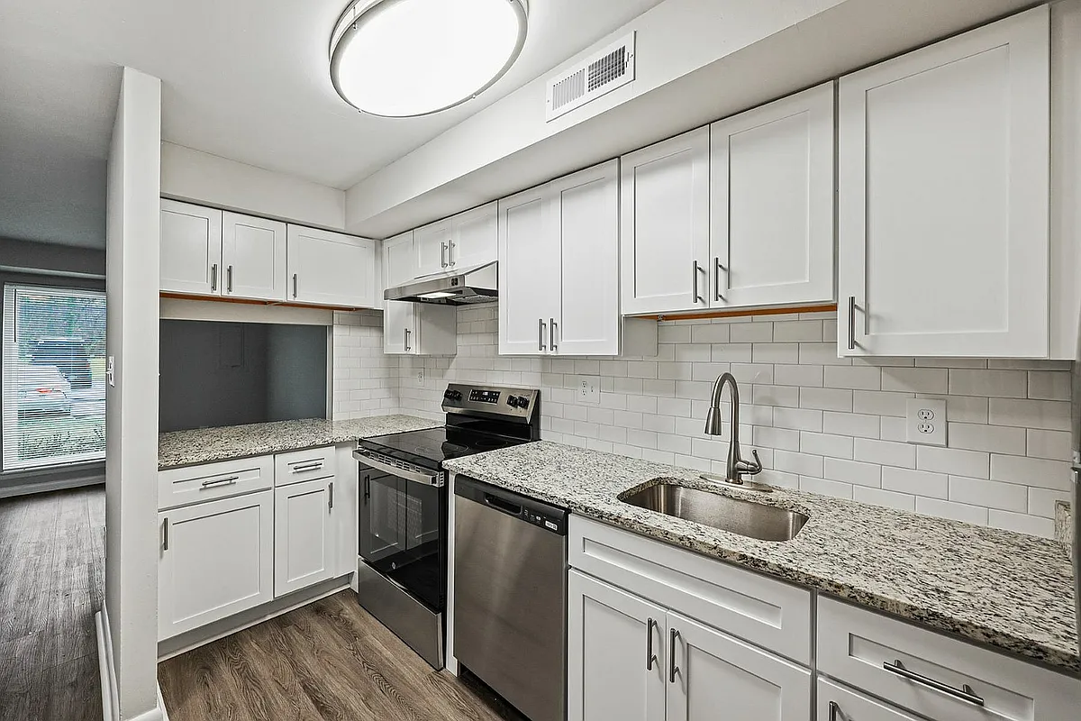 Experience cooking in a modern kitchen with stylish finishes and ample storage. - Beacon Pointe Apartments and Townhomes